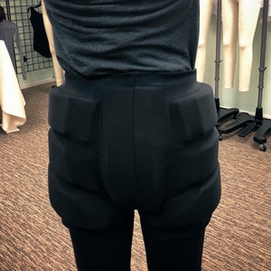 May include: Black padded leggings with a high waist and thick padding on the hips and thighs.