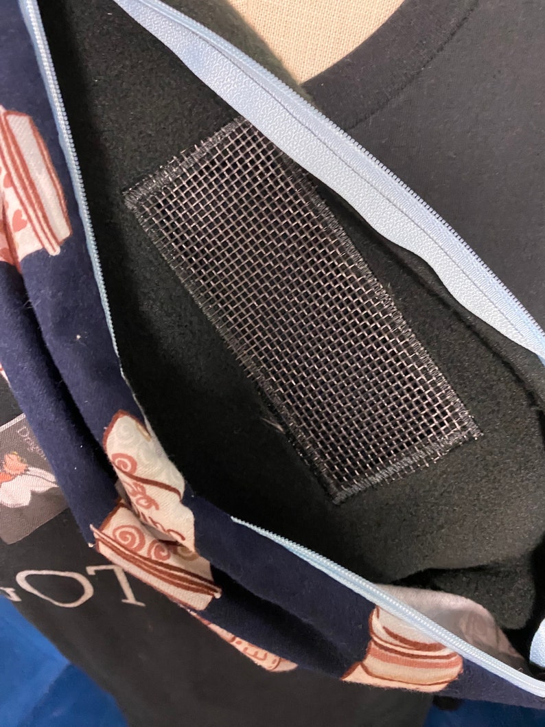 以下が含まれることがあります： 青いジッパーと内側にメッシュポケットが付いた黒いフード付きスウェットシャツ。フード付きスウェットシャツには、茶色と白のコーヒーカップの模様があります。