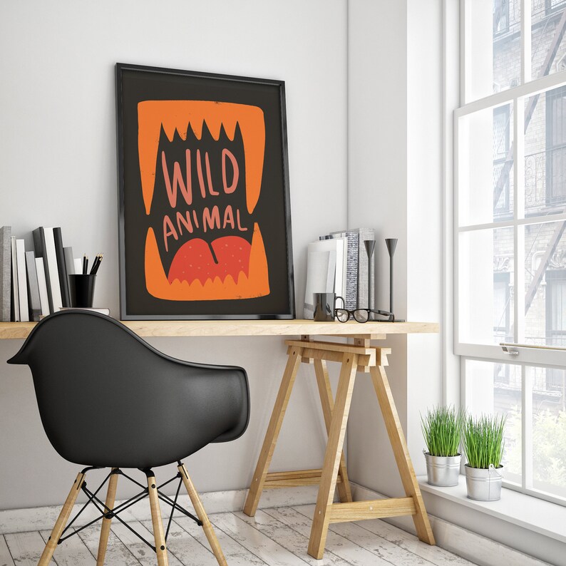May include: A black framed poster with an orange and red illustration of a mouth with sharp teeth and the text "WILD ANIMAL" in white.