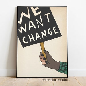 Op de afbeelding: Een zwart-witte poster met een hand die een bord vasthoudt met de tekst "WE WANT CHANGE". De poster heeft een beige achtergrond en de tekst is in een vet, sans-serif lettertype.