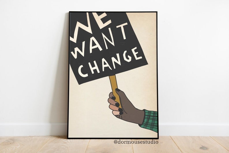 Op de afbeelding: Een zwart-witte poster met een hand die een bord vasthoudt met de tekst "WE WANT CHANGE". De poster heeft een beige achtergrond en de tekst is in een vet, sans-serif lettertype.