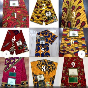 May include: Nine different fabric patterns in red, yellow, blue, and black. Each pattern is a different design, including floral, geometric, and abstract patterns. The fabric is folded in half and has a label with a number on it.