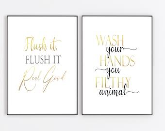 May include: Two white framed prints with black text and gold lettering. The first print says "Flush it. FLUSH IT Real Good". The second print says "WASH your HANDS you FILTHY animal".