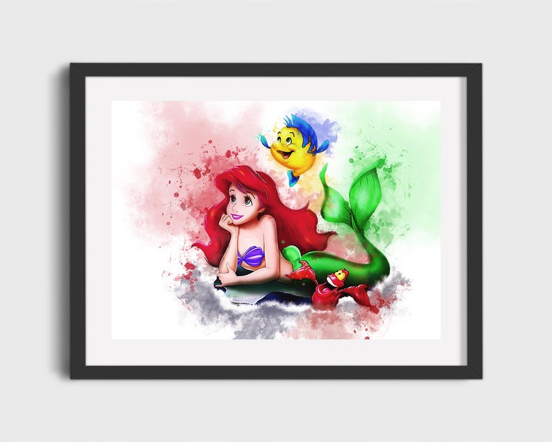 May include: A watercolor illustration of Ariel, the Little Mermaid, with her red hair and green tail. She is swimming with Flounder, a yellow fish with blue fins, and Sebastian, a red crab. The background is a soft pink and green watercolor wash.