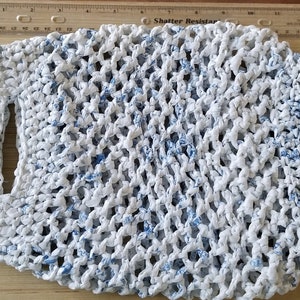 May include: White crocheted bag with blue accents. The bag has a handle and is made from recycled materials.