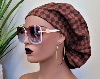Puede incluir: Un gorro bouffant de tela a cuadros blancos y marrones con una banda blanca. El gorro se lleva en un maniquí con gafas cuadradas grandes.