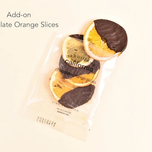 May include: A clear plastic bag filled with chocolate covered orange slices. The bag is labeled "Dardiman's California chocolate orange slices".