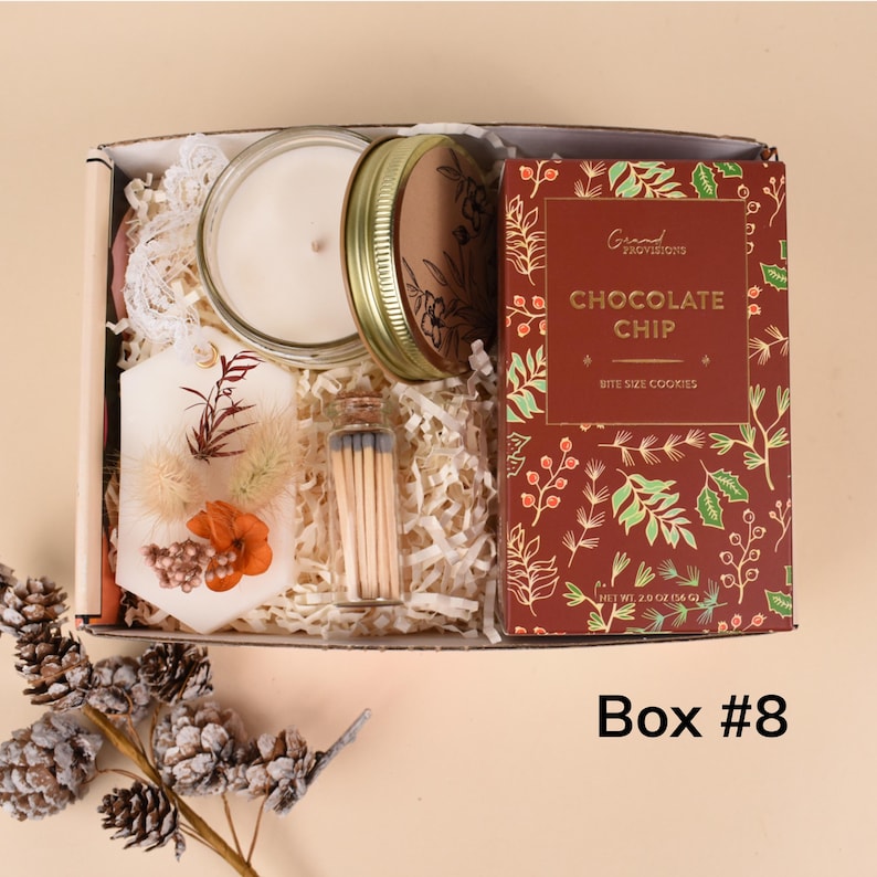 May include: A gift box contains a candle, a jar of matches, a decorative wax tablet with dried flowers, and a box of chocolate chip cookies. The cookie box is red with green and gold floral designs. The box is labeled "Box #8".