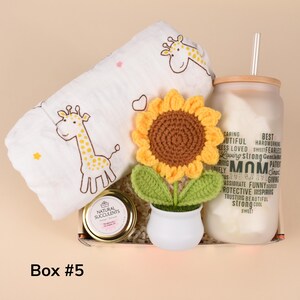 May include: A gift box with a white giraffe-patterned blanket, a crochet sunflower in a white pot, a glass jar with a straw, and a jar of succulents. The glass jar has the word "MOM" and other words printed on it. The box is labeled "Box #5".