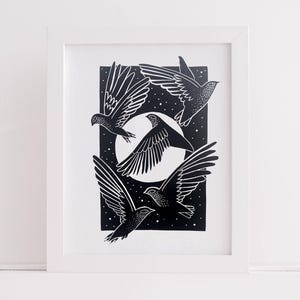 Può includere: Una stampa artistica in bianco e nero incorniciata con quattro uccelli in volo. Gli uccelli sono silhouette contro un cielo stellato con una luna piena. L'opera d'arte è presentata in una cornice bianca, creando un'estetica pulita e moderna.