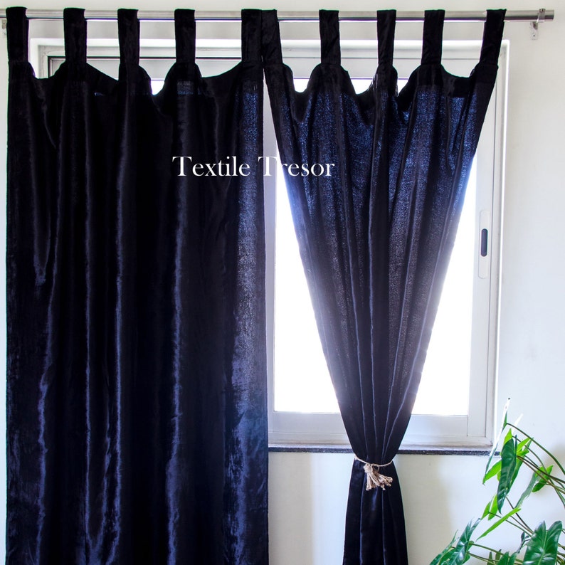 Puede incluir: Un par de cortinas de terciopelo azul oscuro con lazos para atarlas, colgadas en una ventana. Las cortinas est&aacute;n forradas con un tejido azul m&aacute;s claro. El texto "Textile Tresor" es visible en las cortinas.