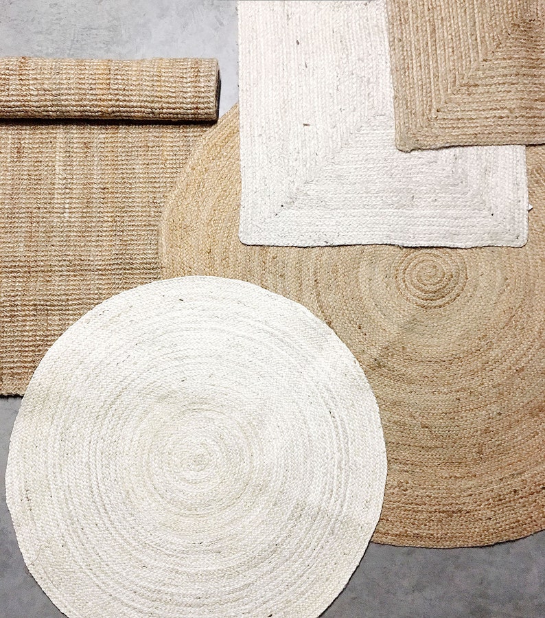May include: A set of four jute rugs in various shapes and sizes. The rugs are made of natural jute fibers and have a woven texture. The rugs are in shades of beige and white.