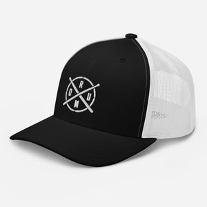 Op de afbeelding: Zwarte en witte truckercap met een wit geborduurd logo van gekruiste drumsticks en het woord "DRUM" in een cirkel.