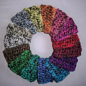 May include: A circle of crocheted headbands in various colors, including black, brown, green, blue, purple, red, pink, orange, yellow, and gray.