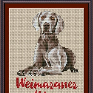 Op de afbeelding: Kruissteekpatroon van een zittende Weimaraner-hond met de tekst "Weimaraner Mom" eronder. Het patroon is op een beige achtergrond met rode tekst.