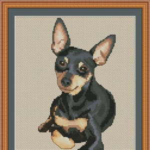 May include: Cross stitch pattern of a black and tan Miniature Pinscher dog sitting with its head tilted. The pattern is titled "Mini Pinscher Mom" and includes the website "PuntAGOpetitePatternetsy.com".