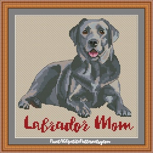 May include: Cross stitch pattern of a black Labrador Retriever dog sitting with its tongue sticking out. The pattern is titled "Labrador's Mom".