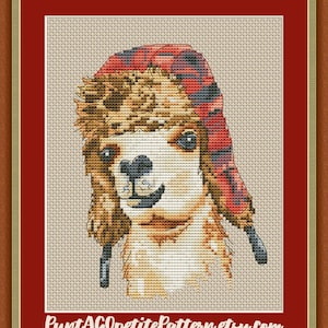 May include: A cross-stitch pattern of an alpaca wearing a red and black plaid hat. The alpaca has brown fur and a white face. The pattern is on a beige background.