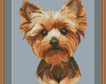 May include: Cross stitch pattern of a Yorkshire Terrier dog with brown and tan fur. The dog is looking directly at the viewer with a serious expression. The background is a light blue color.
