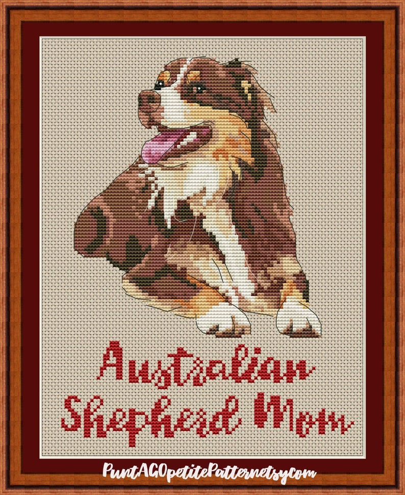 May include: Cross stitch pattern of an Australian Shepherd dog with brown, white, and black fur. The dog is sitting with its tongue sticking out. The text "Australian Shepherd Mom" is below the dog.