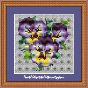 May include: Cross stitch pattern featuring a cluster of purple, yellow, and white pansies with green leaves. The pattern is titled "Petite Pattern" and includes the website "PuntAGOpetitePatterns.etsy.com".