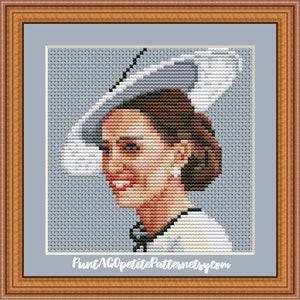 May include: Cross-stitch pattern of a woman wearing a white hat and a white dress. The pattern is on a blue background. The text "PuntAGOpetitePatternsetsy.com" is at the bottom of the pattern.