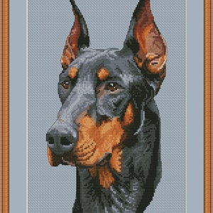 May include: A cross-stitch pattern of a Doberman Pinscher dog with black and tan fur. The dog is looking to the left of the image. The pattern is on a light blue background.