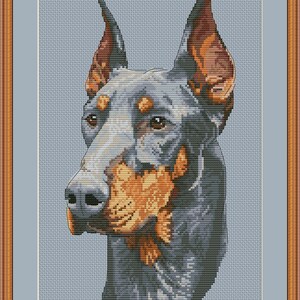 May include: A cross-stitch pattern of a Doberman Pinscher dog with black and tan fur. The dog is looking to the left of the image with its ears perked up.
