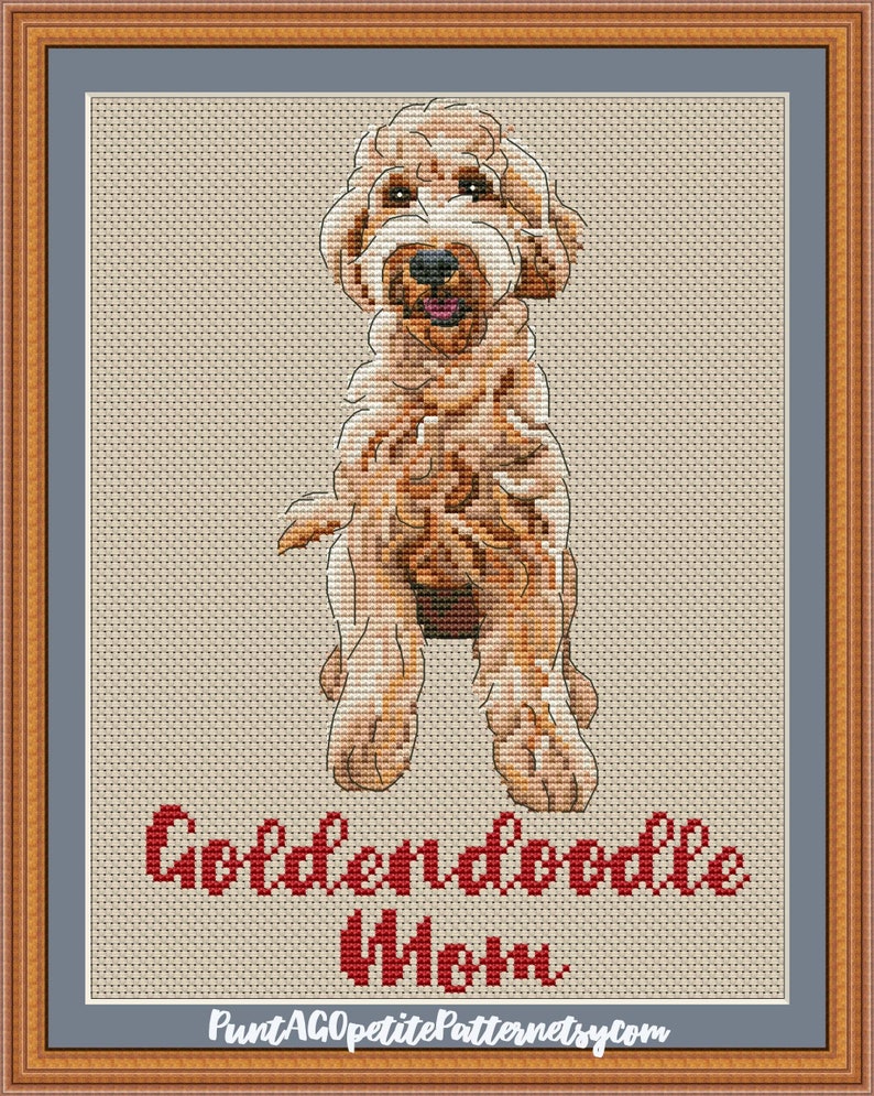 May include: Cross stitch pattern of a golden doodle dog named "Wren". The pattern is in a brown frame with a blue mat.