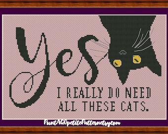 以下が含まれることがあります： 薄いピンクの背景に黒い文字でYESとI REALLY DO NEED ALL THESE CATSと書かれたクロスステッチパターン。右側には黄色い目をした黒猫が逆さまに配置されています。デザインは濃い紫色の枠で囲まれています。