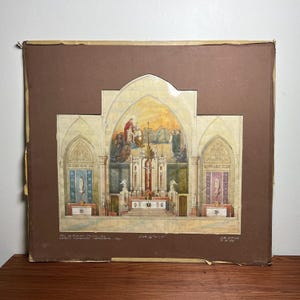May include: An architectural watercolor rendering of a church interior, featuring an altar, stained glass, and religious figures. The artwork is mounted on a brown backing with handwritten text at the bottom, including the location and date.