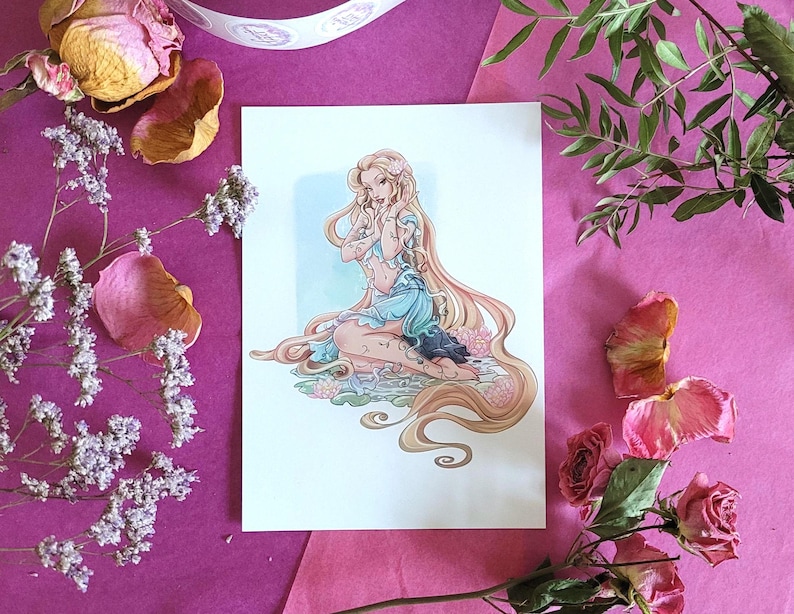 Peut inclure: Une impression d'une femme aux longs cheveux blonds et tatouages, v&ecirc;tue d'une robe bleue. L'&oelig;uvre est entour&eacute;e de fleurs et de feuillages roses et violets, sur un fond rose.