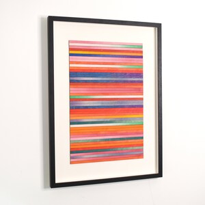 May include: A framed abstract art piece with a colorful striped pattern in shades of red, orange, yellow, green, blue, and purple. The stripes are made of wood and are arranged in a horizontal pattern.