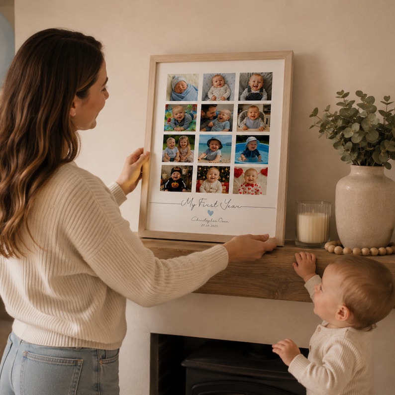 May include: A rectangular wooden picture frame containing a collage of twelve photographs of a baby. The print features the text My First Year, the name Christopher Owen, and a date. The frame is light-toned wood with a white mat border.