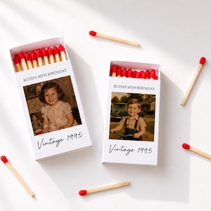 May include: Two white matchboxes filled with red-tipped matches. Each box features a custom photograph, the text "RUTH'S 30TH BIRTHDAY," and the script text "Vintage 1995." Several loose red-tipped matches are scattered around the two boxes.