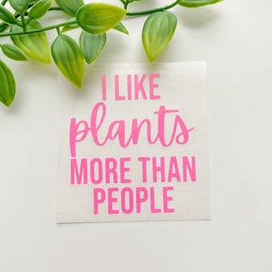 May include: A white sticker with pink text that reads "I like plants more than people".