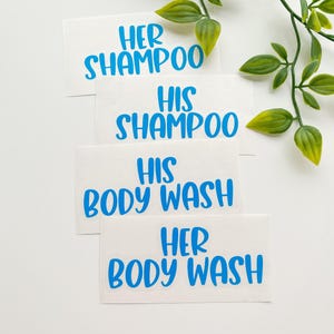 May include: Four rectangular white adhesive labels with bright blue text. The labels read HER SHAMPOO, HIS SHAMPOO, HIS BODY WASH, and HER BODY WASH in a bold, sans-serif font. The labels are arranged in a vertical stack on a plain white surface.