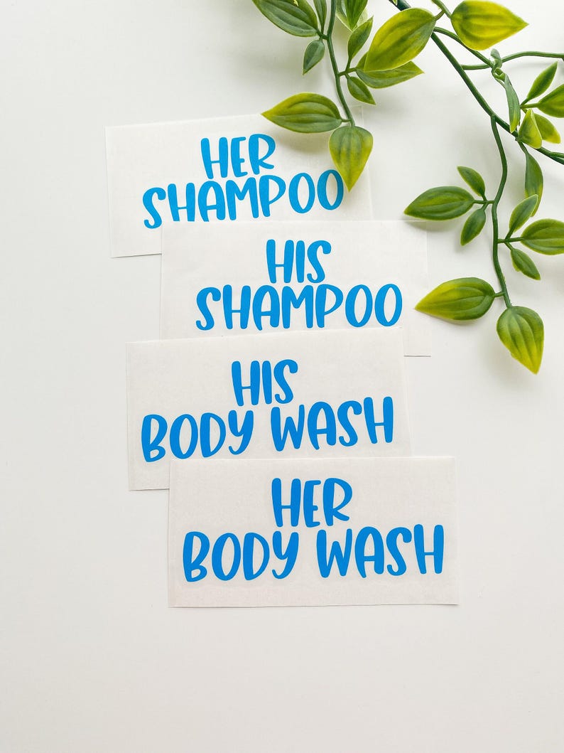 May include: Four rectangular white adhesive labels with bright blue text. The labels read HER SHAMPOO, HIS SHAMPOO, HIS BODY WASH, and HER BODY WASH in a bold, sans-serif font. The labels are arranged in a vertical stack on a plain white surface.