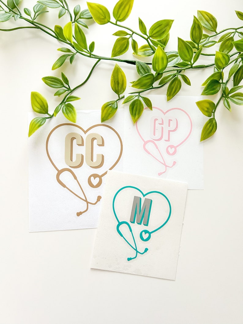 Peut inclure: Trois autocollants blancs en forme de c&oelig;ur avec un st&eacute;thoscope. Les c&oelig;urs sont remplis de diff&eacute;rentes couleurs&nbsp;: or, rose et turquoise. Les initiales &laquo;&nbsp;CC&nbsp;&raquo;, &laquo;&nbsp;GP&nbsp;&raquo; et &laquo;&nbsp;M&nbsp;&raquo; sont &agrave; l&rsquo;int&eacute;rieur des c&oelig;urs.