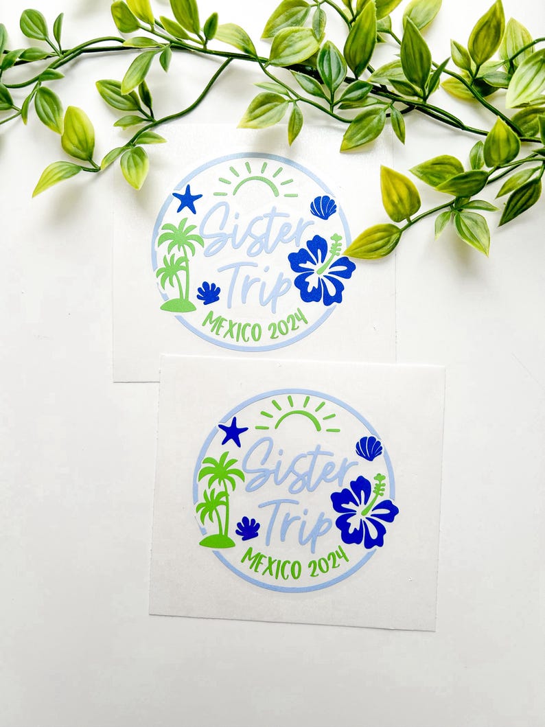 Puede incluir: Dos pegatinas circulares de vinilo con un borde azul claro, un sol verde, palmeras, una estrella de mar azul, una concha y una gran flor de hibisco azul. El texto dice Sister Trip MEXICO 2024 en una mezcla de fuentes azul claro y verde.