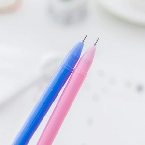May include: Two pens, one blue and one pink, with silver tips.
