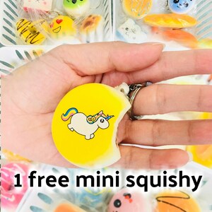 Puede incluir: Una colecci&oacute;n de mini squishies coloridos, que incluye un llavero de unicornio amarillo y varios juguetes con forma de comida. La imagen incluye el texto "1 free mini squishy".