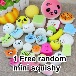 May include: A collection of colourful, soft, and squishy toys in various shapes, including animals, food, and geometric shapes. The toys are arranged on a white surface. The text "1 Free random mini squishy" is visible in the image.
