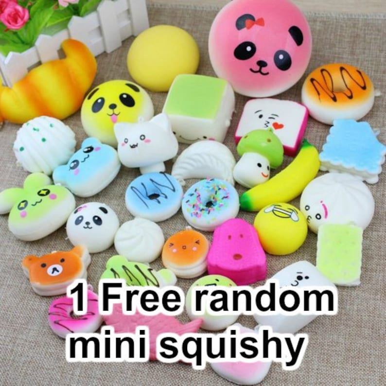 May include: A collection of colourful, soft, and squishy toys in various shapes, including animals, food, and geometric shapes. The toys are arranged on a white surface. The text "1 Free random mini squishy" is visible in the image.