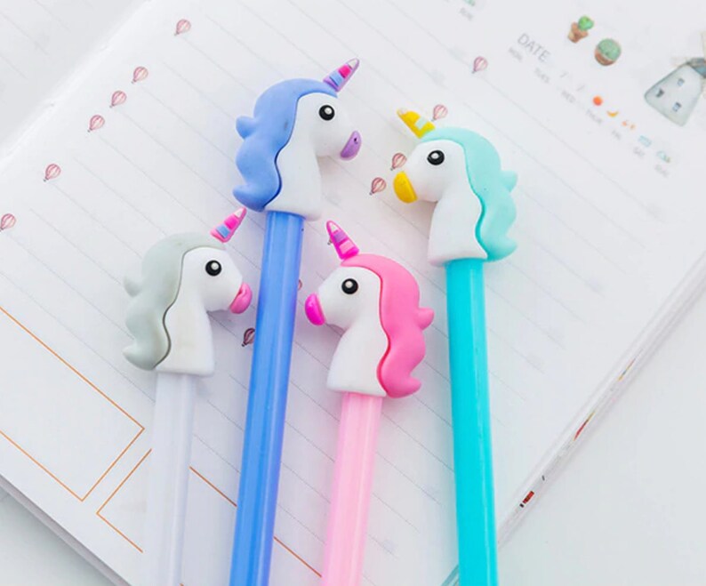 May include: Four unicorn-shaped pens with different colored bodies: blue, pink, light blue, and white. The unicorn heads are all white with different colored manes and horns.