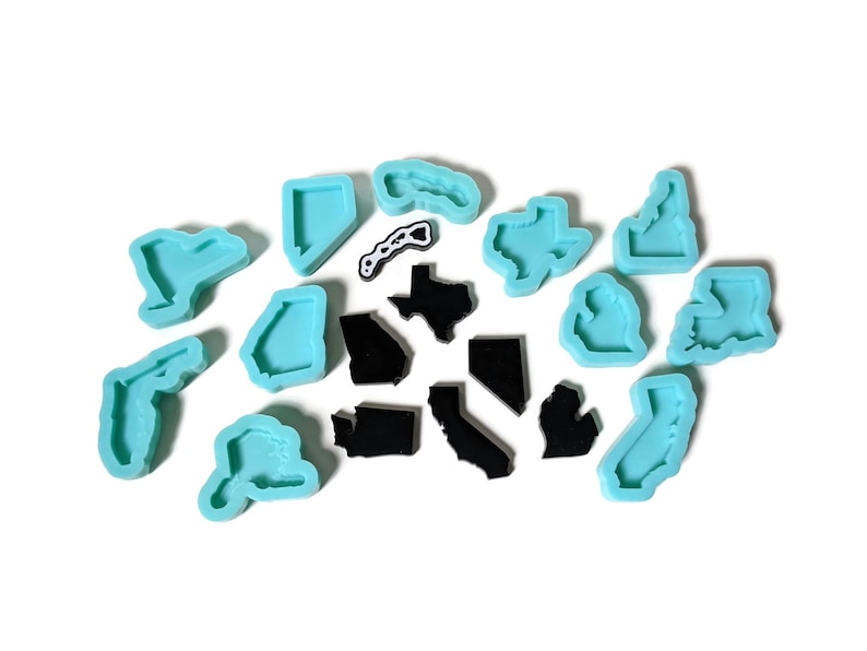 May include: A set of 14 silicone molds in the shape of US states. The molds are light blue and are arranged in a random pattern on a white background.