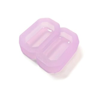 Puede incluir: Un molde de silicona rosa claro con dos cavidades rectangulares. El molde está diseñado para hacer manualidades de resina.