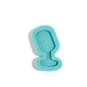 May include: A teal blue silicone mold shaped like a vintage microphone.