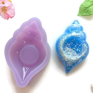 May include: A purple silicone seashell mold and a blue seashell resin casting with glitter.