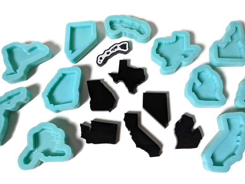 May include: A set of silicone molds in the shape of US states, including Texas, California, Georgia, and Florida. The molds are turquoise blue. There are also black resin castings of the same states.